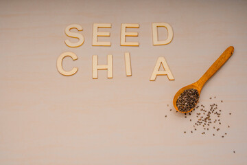 Chia seeds in a wooden bowl with a wooden spoon