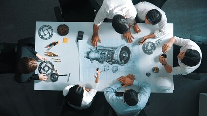Top view of skilled engineer writing and measure turbine engine by using pencil. Aerial view of...
