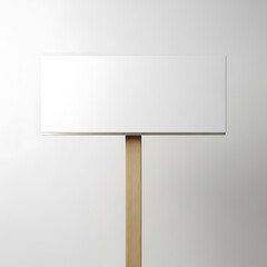 Fototapeta premium A minimalist white rectangular sign mounted on a wooden pedestal