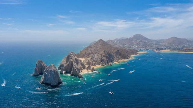 Panoramic aerial view of Land&rsquo;s End at the southern tip of the Baja California Peninsula in Cabo San Lucas, Mexico. The shot reveals the iconic rock formations, turquoise waters of the Sea of Cortez.