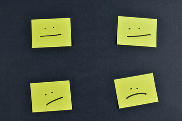 Nine yellow cards with varied facial expressions on dark background, illustrating a range of emotions through minimalistic design and layout.