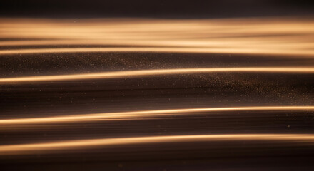 Blurry image of golden light streaks on dark background