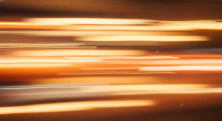 Blurred abstract light trails in warm orange and yellow hues