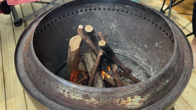 Having fire in metal smokeless drum burn barrel on DIY wooden deck in studio flat in New Zealand.