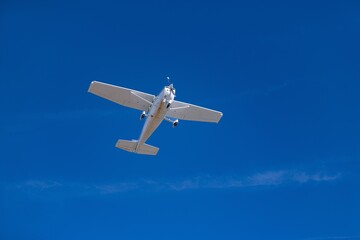 Small propeller airplane flying in clear blue sky
