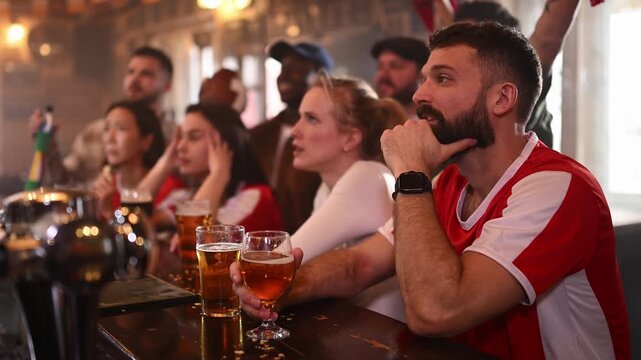 Excited football fans celebrating victory while watching game in a pub