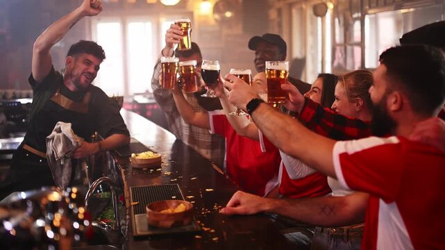 Cheerful football fans toasting beer in a pub