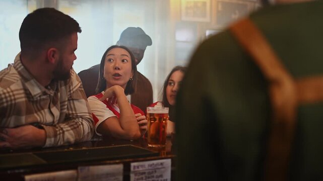 Diverse group of friends chatting and laughing at a bar counter