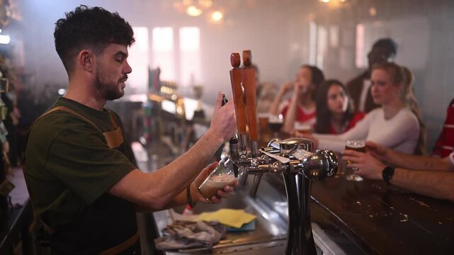 Bartender pouring a craft beer from a tap in a sports bar