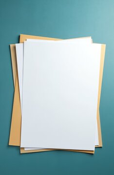 Top view of stack of blank white paper sheets and manila folders on blue office desk. Documents await review or filing for job search, business planning, or office work organization.