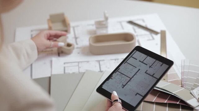 Architectural planning with tablet and blueprint on desk, arranges furniture and plumbing of bathroom.