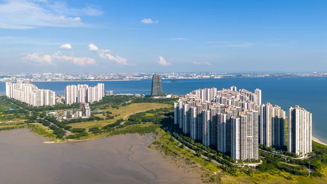 Aerial panoramic view of Forest City, an artificial island, built in Johor Bahru, Malaysia, Singapore can be seen at the distance as background.
