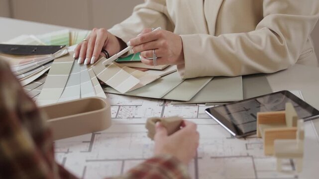 Collaborative interior design planning with color swatches and architectural models.