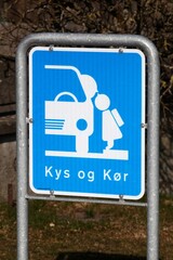 Kiss and drive area road sign in front of a school in Denmark