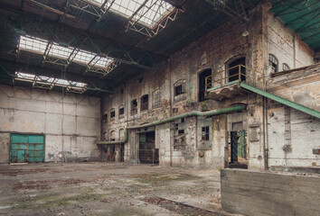 Abandoned industrial factory hall interior with decay and broken windows