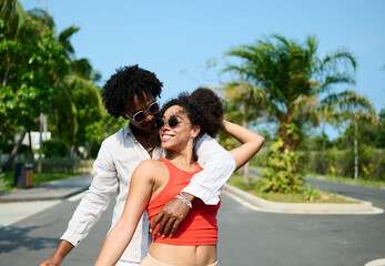 Portrait of a young couple at the beac in summertime,  a man and a woman are playing with a blue...