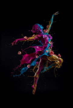 Creative high speed photography art of a jumping woman ballerina figure formed by exploding gold, blue and pink water paints and flower petals against black background