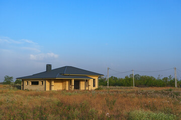 A modern brick house under construction in a new, environmentally friendly neighborhood.