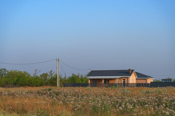 A modern brick house under construction in a new, environmentally friendly neighborhood.