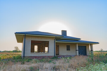A modern brick house under construction in a new, environmentally friendly neighborhood.