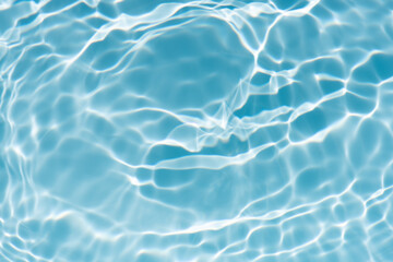 Obraz premium Blue water with ripples on the surface. Defocus blurred transparent blue colored clear calm water surface texture with splashes and bubbles. Water waves with shining pattern texture background.
