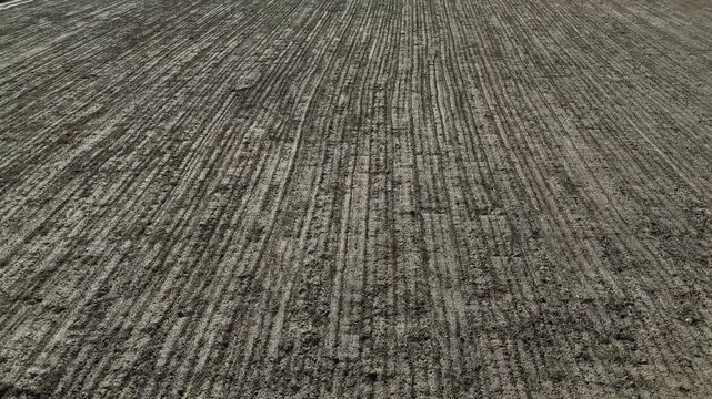 Plowed soil field texture with parallel lines top view