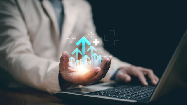 Business growth and digital success concept. Businessman working on laptop while holding virtual upward arrows. representing data analytics, financial growth, innovation and investment strategy.