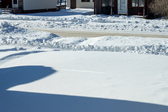 snow covered yard with icy street in winter