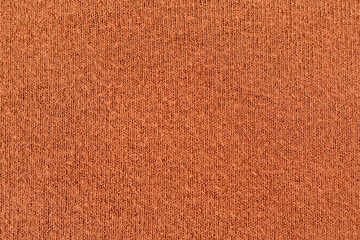 Warm knitted sweater fabric texture in terracotta color