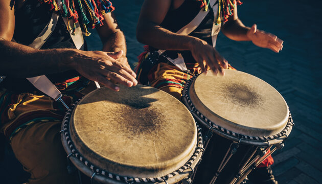 People playing drums in a park. Scene is lively and energetic.