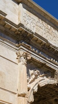ornate roman triumphal arch carved corinthian columns friezes latin inscriptions coffered ceiling under clear sky rome italy coffer architecture historic monument 