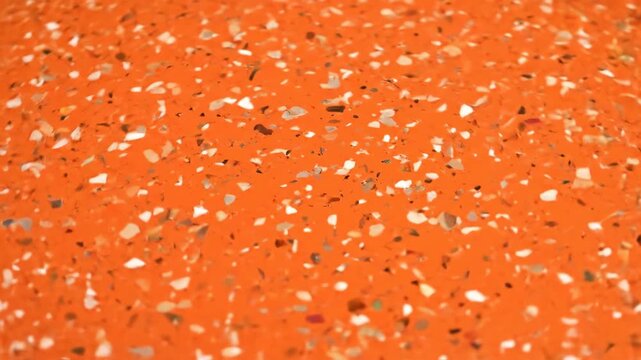 Vibrant orange terrazzo floor with white and brown marble chips creating a unique pattern perfect for interior design projects and architectural visualizations.