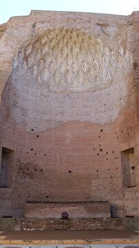 large ancient brick hall rome italy has coffered apse ceiling purple red marble columns scattered fragments ornate stone floor illuminated by daylight coffer purple-red 