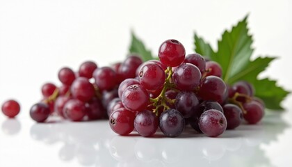 Obraz premium Red grapes with green leaves on white background. Fresh juicy berries close up isolated. Natural healthy fruit ingredient for food and drink.