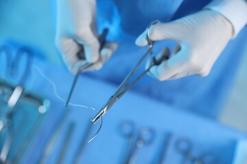 Doctor with different surgical tools at table in hospital, above view
