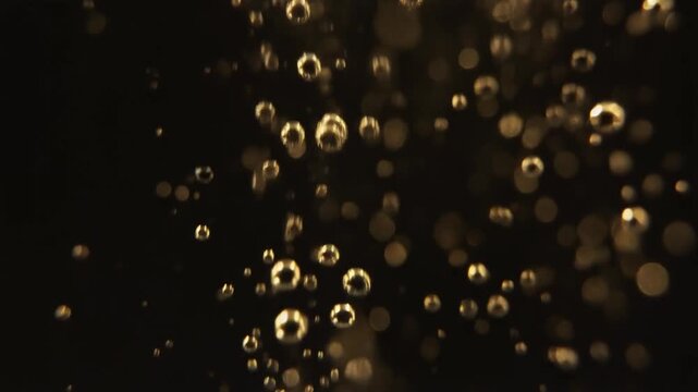 Mesmerizing golden bubbles ascending through a dark liquid, creating a dynamic and effervescent abstract background texture with a vibrant glow