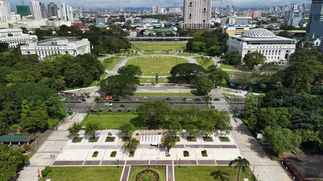 Aerial view of Rizal Park in Manila, Philippines, showcasing expansive green lawns, monuments, and surrounding neoclassical museum buildings with the city skyline in the background.