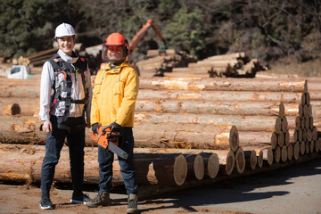 林業など第一次産業で働く人複数の人　高所作業や木を切るチェンソーのチームの全身カメラ目線(多摩木材センター協同組合プロパティ許可ずみ）