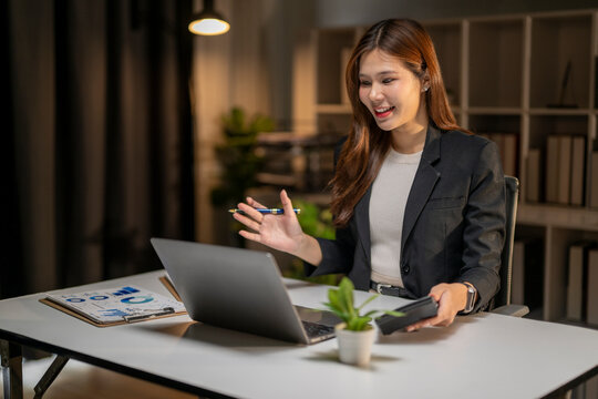 Businesswoman having video conference call working late at office - Powered by Adobe