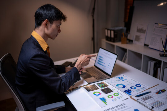 Professional man analyzing financial data working late - Powered by Adobe