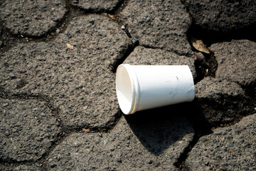 Eco-friendly disposable white and yellow paper cups and glasses used from water station for runner, coffee cafe, restaurants, takeaways. Disposal garbage waste recycle. Close up.