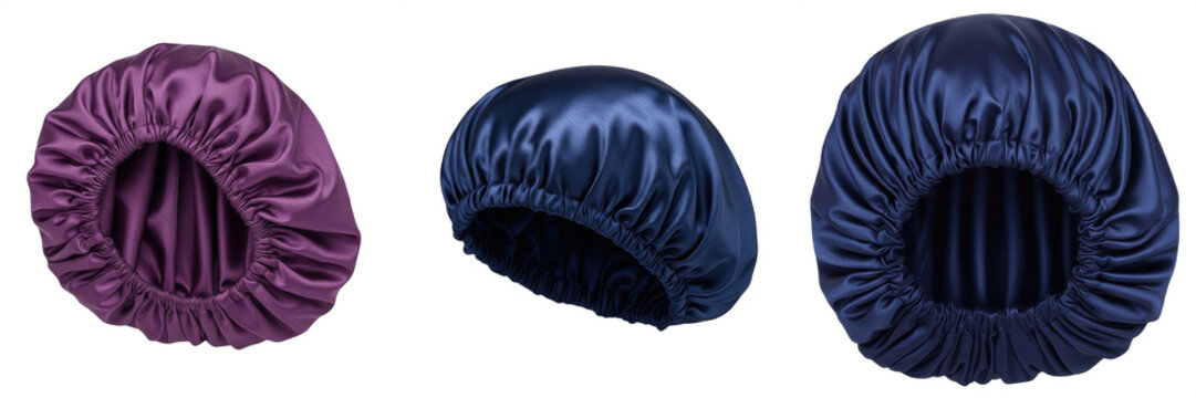 Set of luxury satin silk sleep bonnets for hair protection, purple and navy blue elastic night caps isolated on white background for beauty and hair care.