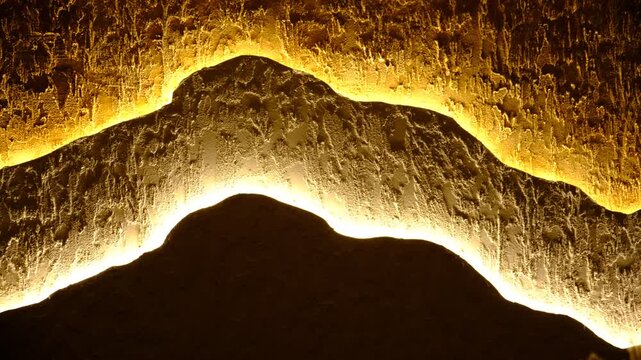 Modern apartment with three-layer wall , multilayer textured polymer mineral plaster, Abstract wavy curve panel wall, installed with hidden glowing led, provides illumination for fashion interior