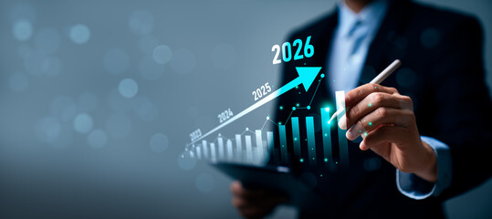 Business professional using tablet, stylus to illustrate upward financial growth chart from 2023 to...