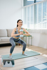 Obraz premium Fitness woman exercising with dumbbells at home. Healthy lifestyle, home workout, online fitness training, wellness, strength exercise and modern living concept.