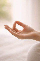 Gentle human hand gesture in soft indoor light for wellness, mindfulness, and calm design use