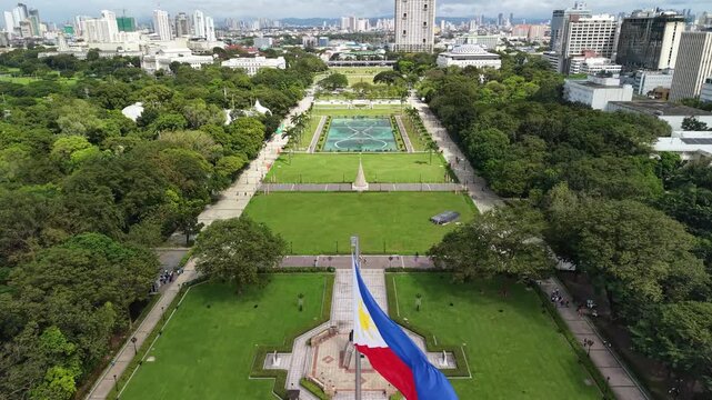 Aerial view from the Philippine flag monument across Rizal Park in Manila with symmetrical gardens fountains lawns and city skyline