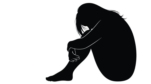 A solitary figure sits with head in hands conveying sadness silhouette