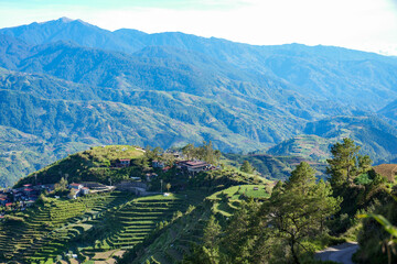 Terraced Farming Village on Mountain Hillside with Lush Green Landscape
