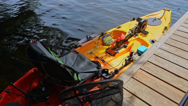 Fully rigger kayak like drone watercraft with electric trolling underwater motors is mooring and tied to boat pier near cottage boat house. Recreational watercraft, works with remote, kayaking lake.